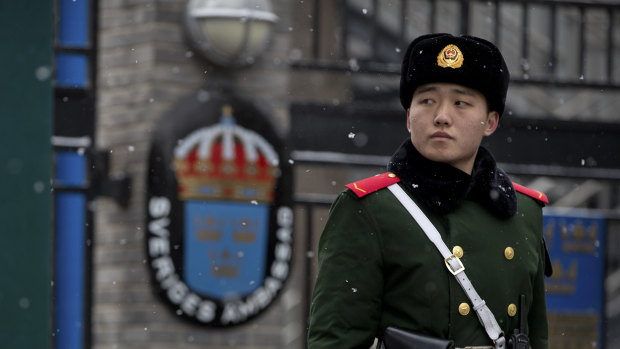 A paramilitary police officer stands guard at the gate of the Swedish Embassy in Beijing.