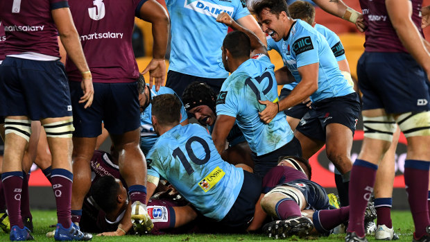 Against the odds: Kurtley Beale scores for the embattled Waratahs in the win over the Reds.