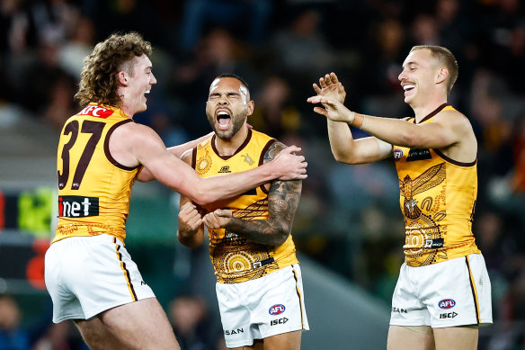 Jarman Impey of the Hawks celebrates a goal with teammates Josh Weddle, left, and James Worpel, right. 