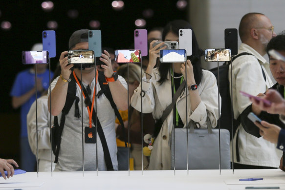 Attendees take a closer look at the Apple iPhone 16 after its announcement.