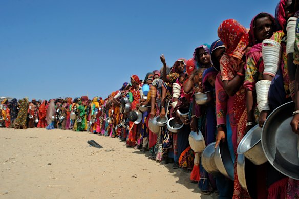 Villagers hit by flooding in Pakistan’s southern Sindh province queue for food in 2022. Floods are now a yearly occurrence.