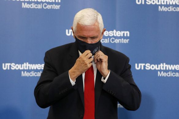 US Vice-President Mike Pence adjusts his mask during a news conference at the University of Texas in Dallas.