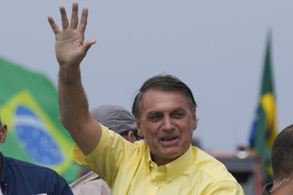 Brazilian President Jair Bolsonaro waves to supporters upon arrival to a motorcycle rally as he campaigns for a second term in Pocos de Caldas, Brazil on Friday, September 30.