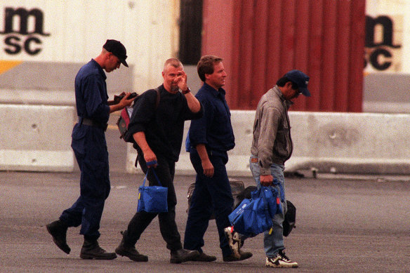 A worker, transported in by helicopter, taunts unionists and media at the gate.