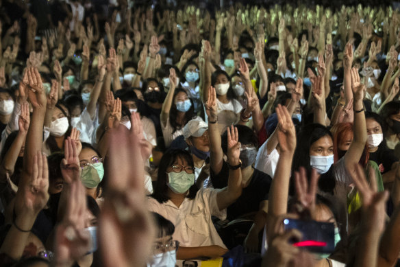 Students raise a three-finger salute, a resistance symbol borrowed from the 'The Hunger Games', during a protest at Thammasat University on Monday.
