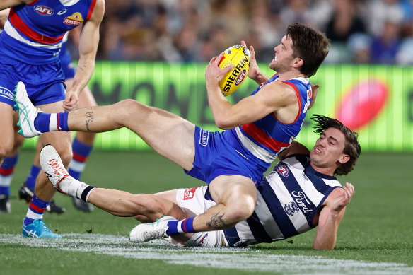 Bailey Williams of the Bulldogs is tackled by Gryan Miers of the Cats.