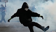 A protester kicks a teargas canister during scuffles following a demonstration against under-resourced schools, in Paris, on Tuesday, October 6.