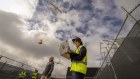 Wing ground operations manager Semira Ragan and Australia operations manager Dave Ojiako-Pettit loading a drone with a parcel in Melbourne.