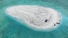 In this photo provided by the Philippine Coast Guard, Filipino scientists are seen on the Sandy Cay sandbank last month.