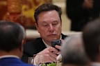 The Tesla chief appears captivated by his phone during the state dinner.