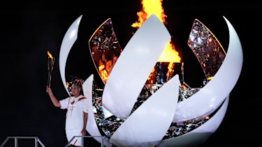 Japanâs Naomi Osaka reacts after lighting the cauldron.