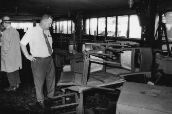 A detective examines the fire-damaged interior of the Whiskey Au Go Go nightclub.