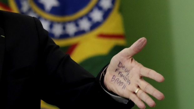 Brazil's Evangelical President Jair Bolsonaro's hand shows notes that read in Portuguese "God, Family, Brazil", during a speech in Brasilia last week.