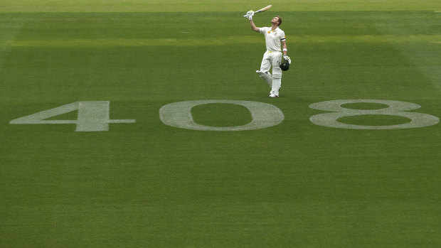 Smith raises his bat to the sky after reaching a century against India at Adelaide.