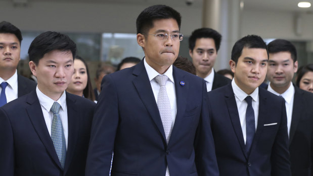Leader of the Thai Raksa Chart party Preechapol Pongpanich, centre, leaves the Constitutional Court in Bangkok on Thursday.