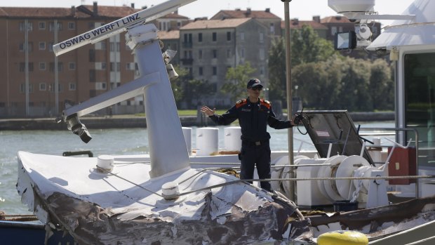 Italian Coast Guard officers inspect a tourist boat that was struck by the cruise ship.