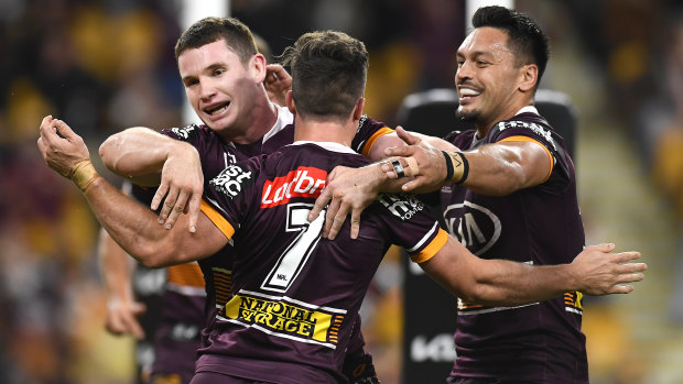 Broncos players celebrate during their win over the Cowboys on Friday night at Suncorp Stadium.