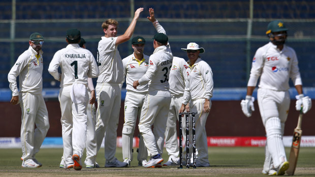 Cameron Green celebrates with teammates after taking the wicket of Faheem Ashraf.