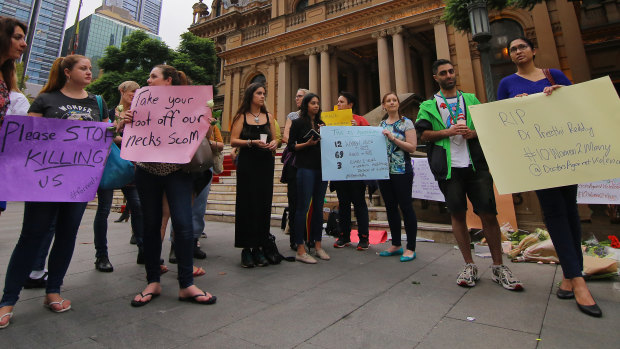 Mourners hold placards during a candlelight vigil for murdered Sydney dentist Preethi Reddy.