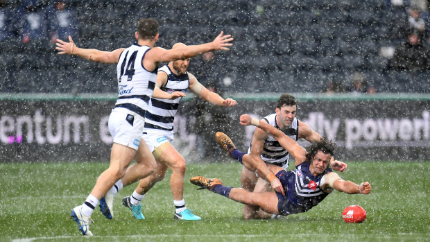 Fremantle's Brady Grey battles a pack of Cats and the wet conditions.