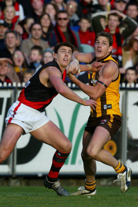 Essendon’s Matthew Lloyd and Hawthorn’s Danny Jacobs battle for the ball.