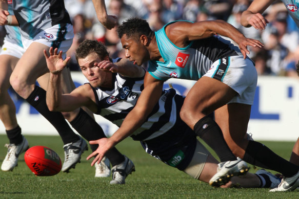 Port’s David Rodan and Geelong’s Cameron Mooney dive for the ball.