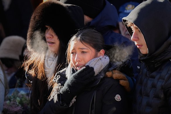 Mourners weep for the victims of the Crans-Montana fire at a memorial procession on Sunday.