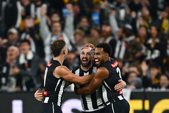 Collingwood’s Steele Sidebottom celebrates with Dan Houston (left) and Isaac Quaynor after kicking a goal.