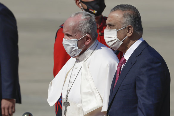 Pope Francis is flanked by Iraqi Prime Minister Mustafa al-Kadhimi upon his arrival at Baghdad’s international airport.
