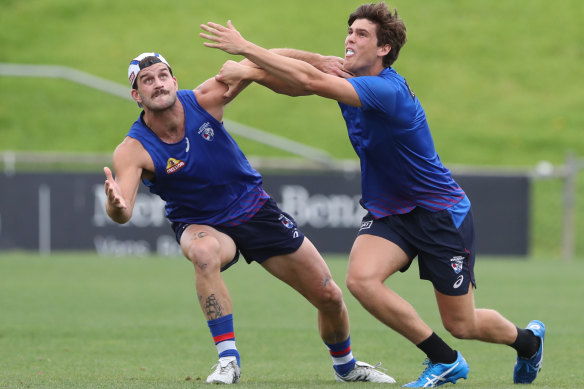 Josh Bruce (left) in a contest with Lewis Young at Bulldogs training on Monday.