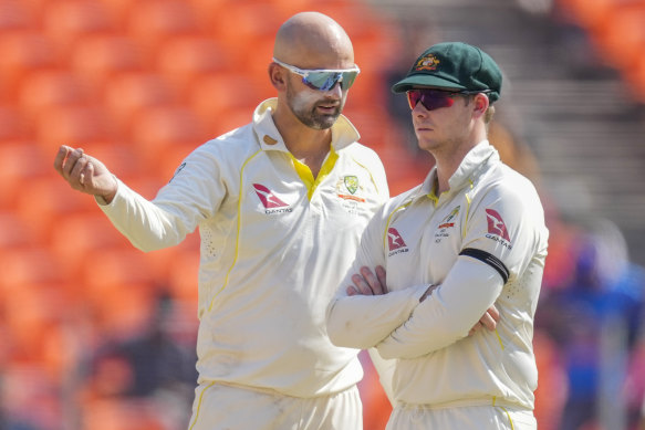 Nathan Lyon discusses field placements with acting captain Steve Smith. Lyon bowled 65 overs.