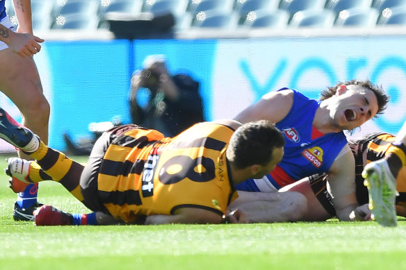 Toby McLean grimaces in pain after a tackle by Hawk Jonathon Ceglar. 