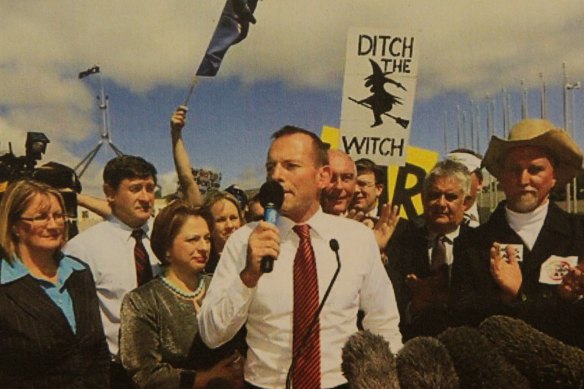 Then-opposition leader Tony Abbott
addresses an anti-carbon tax rally in 2011, amid posters vilifying Gillard as prime minister.