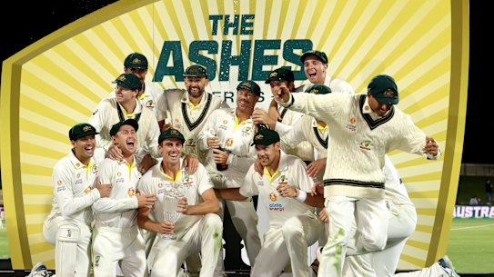 Usman Khawaja jumps off stage as the champagne comes out. 