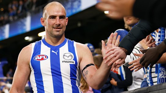 Ben Cunnington high fives North Melbourne fans.