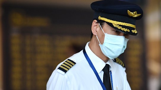 A pilot wearing a mask at Brisbane International Airport in January. Airlines are working out what precautions to put in place as travel demand slowly returns. 
