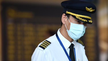 A pilot wearing a mask at Brisbane International Airport in January. Airlines are working out what precautions to put in place as travel demand slowly returns. 