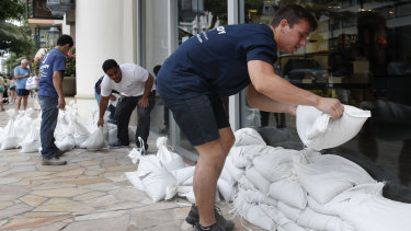 Sandbags are stacked in front of a closed store in Honolulu on Thursday. 