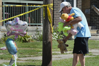 Paul Laughlin, 57, places stuffed animals outside a home where multiple people died in an early-morning fire. 