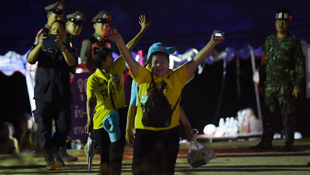 Thai volunteers cheer on news the boys and their coach had been rescued.