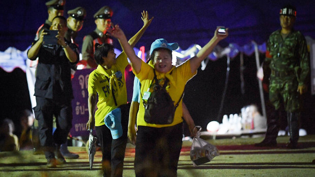 Thai volunteers cheer as they return from Tham Luang cave. 