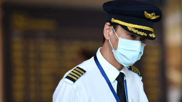 A pilot wearing a mask at Brisbane International Airport in January. Airlines are working out what precautions to put in place as travel demand slowly returns. 