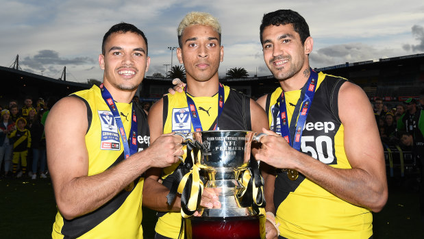 A grand affair: Sydney Stack, Derek Eggmolesse-Smith and Marlion Pickett pose with the VFL premiership trophy.