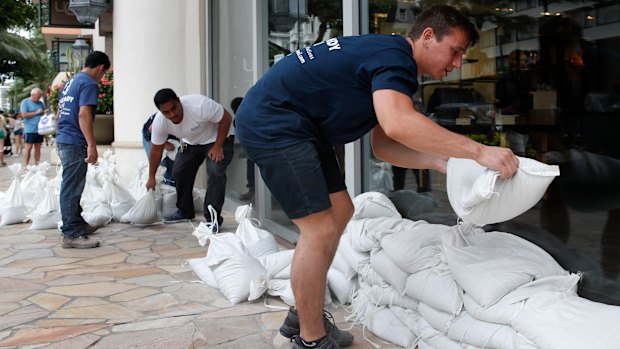 Sandbags are stacked in front of a closed store in Honolulu on Thursday. 