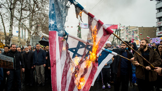 Iranians burn US and Israeli national flags during celebrations marking the 40th anniversary of the Islamic revolution in Tehran.