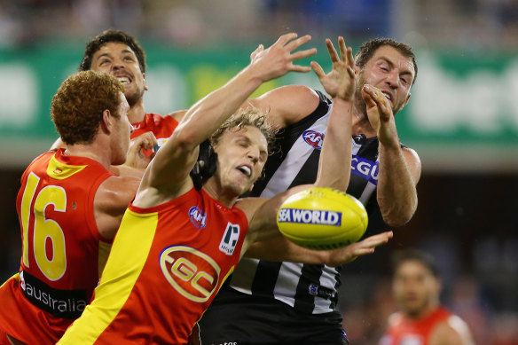 Trent McKenzie of the Suns and Travis Cloke of the Magpies compete for the ball.