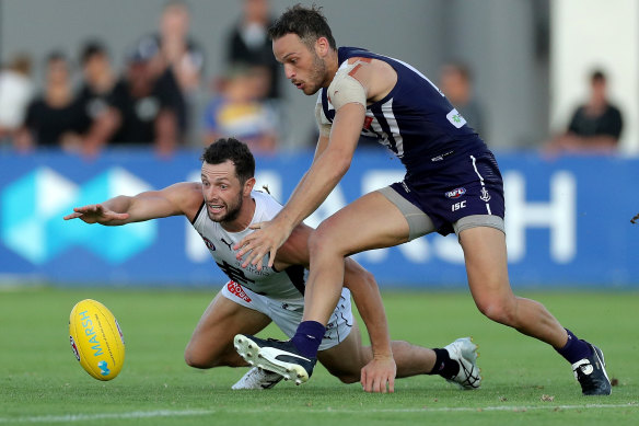 Carlton's Darcy Lang dives for the ball under pressure from Fremantle recruit James Aish.