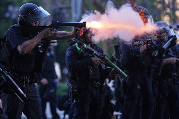A police officer fires a wet round in the center of Los Angeles Sunday.
