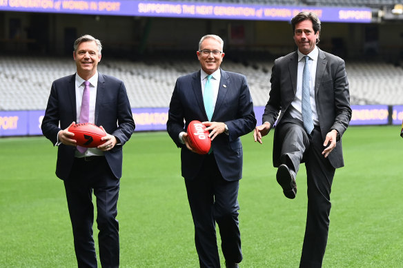 James Warburton and Patrick Delany (from left) pose for a photo with former AFL CEO Gillon McLachlan at the announcement of the code’s broadcast deal in 2022.