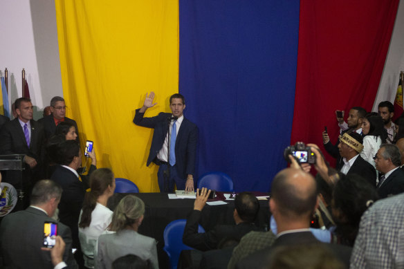 Juan Guaido swears himself in as president of the National Assembly at a newspaper office in Caracas after being blocked from parliament.